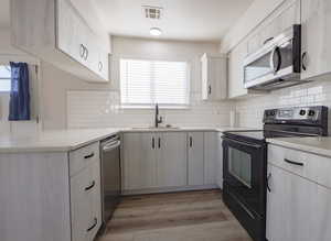 Kitchen featuring sink, appliances with stainless steel finishes, light hardwood / wood-style flooring, and tasteful backsplash