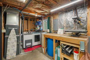 Basement featuring a workshop area, washer/dryer hook-ups, storage, water softener, and electric panel