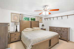 Carpeted bedroom featuring ceiling fan