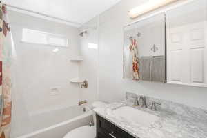 Full bathroom featuring shower / bath combo, toilet, and vanity