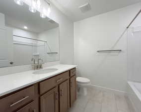 Full bathroom with vanity, tile patterned floors,  shower combination, and toilet