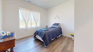 Bedroom with hardwood / wood-style flooring