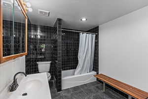 Full bathroom featuring tile patterned flooring, sink, toilet, and shower / tub combo