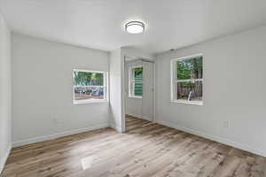 Unfurnished bedroom with light hardwood / wood-style floors and a closet