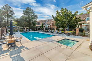 View of swimming pool with a community hot tub and a patio area