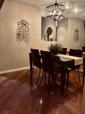 Dining area with wood-type flooring, a notable chandelier, and a textured ceiling