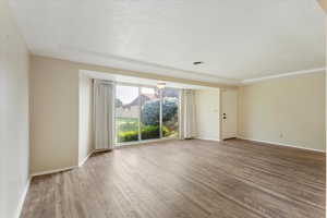 Unfurnished room featuring a textured ceiling and wood-type flooring