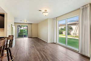 Interior space with a textured ceiling and hardwood / wood-style floors