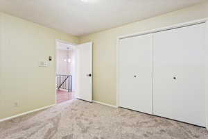 Unfurnished bedroom with light colored carpet and a closet