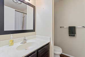 Bathroom with toilet, vanity, and a textured ceiling