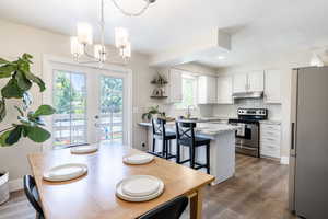 Interior space featuring hardwood / wood-style flooring, a healthy amount of sunlight, and a notable chandelier