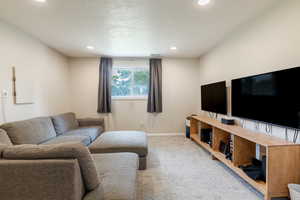 Carpeted living room with a textured ceiling