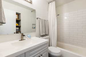 Full bathroom with shower / bath combination with curtain, toilet, and vanity