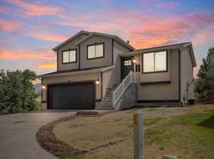 View of front of property with a garage and a lawn