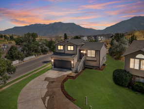 View of front of house with a garage, a yard, and a mountain view *This photo has been VIRTUALLY updated to show the yard potential*