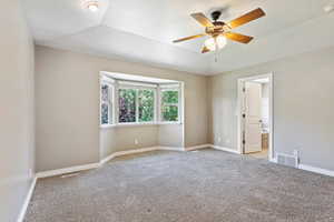 Unfurnished room with ceiling fan, lofted ceiling, and light colored carpet