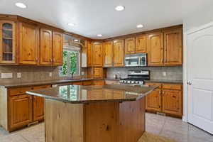 Kitchen featuring a center island, decorative backsplash, and stove