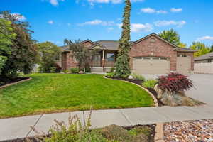 Single story home featuring a garage and a front lawn