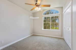 Unfurnished bedroom with a closet, carpet flooring, ceiling fan, and vaulted ceiling