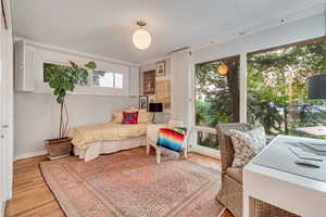 Main floor Bedroom featuring original hardwood floors and  views of the backyard