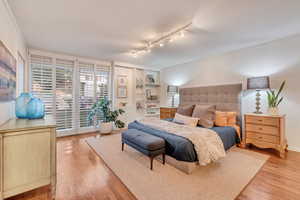 Primary Bedroom with large east facing windows and original hardwood flooring