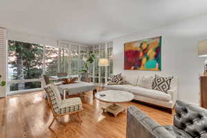 Formal Living room with dining space featuring original hardwood floors and expansive windows