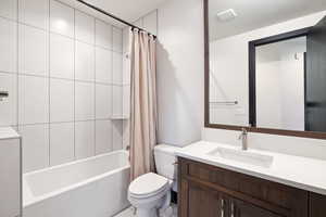 Full bathroom with vanity, toilet, and shower / bathtub combination with curtain