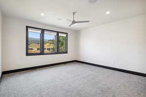 Spare room featuring carpet and ceiling fan