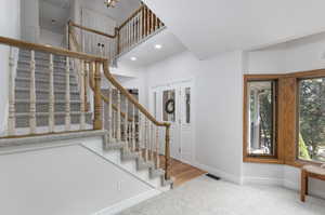 Entryway featuring a healthy amount of sunlight, hardwood / wood-style floors, and a high ceiling