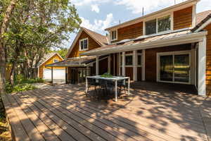 New deck featuring an outdoor structure and a garage