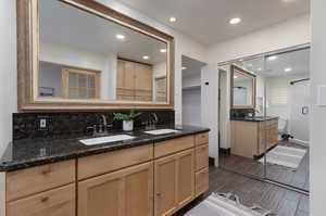 Bathroom featuring hardwood / wood-style floors, double vanity, toilet, and backsplash