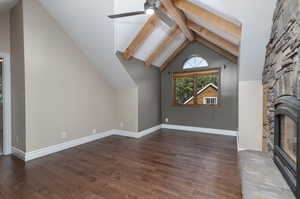 Unfurnished living room with beam ceiling, a fireplace, hardwood / wood-style floors, and ceiling fan