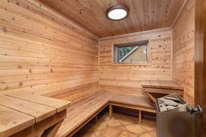 View of sauna / steam room featuring wood ceiling, wood walls, and tile patterned flooring