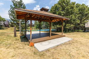 Wooden deck featuring a gazebo and a lawn