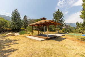 View of property's community featuring a mountain view, a gazebo, and a yard