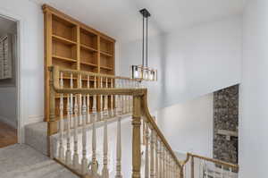 Stairs featuring an inviting chandelier and hardwood / wood-style flooring