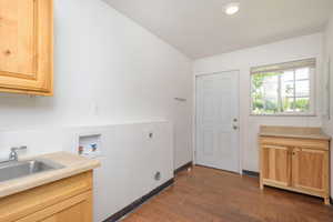 Laundry room featuring dark hardwood / wood-style flooring, sink, electric dryer hookup, cabinets, and washer hookup