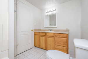 Bathroom with tile patterned floors, toilet, and vanity