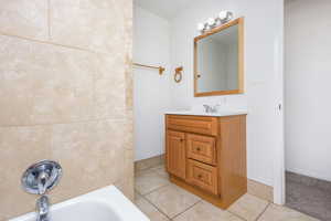 Bathroom with vanity, tile patterned flooring, and a bathing tub