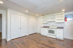 Kitchen featuring white cabinetry, dark hardwood / wood-style floors, and white range with electric stovetop