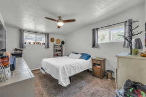 Bedroom with carpet, multiple windows, and ceiling fan