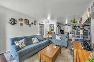 Living room with a textured ceiling and ceiling fan