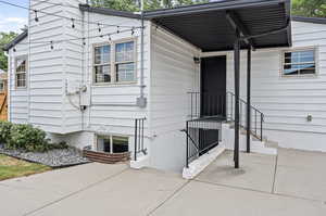 View of rear entrance to property with basement entrance.