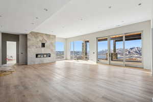 Unfurnished living room featuring a mountain view, light wood-type flooring, and a tile fireplace