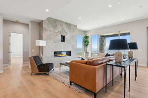 Living room featuring light wood-style floors, recessed lighting, and a fireplace