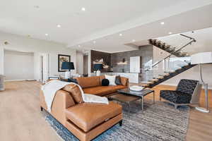 Living area with light wood-type flooring, stairway, and recessed lighting