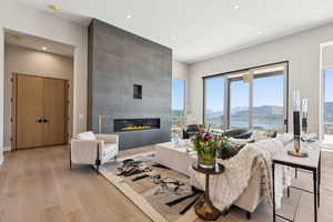Living room featuring light wood-style floors, a tiled fireplace, a mountain view, and recessed lighting