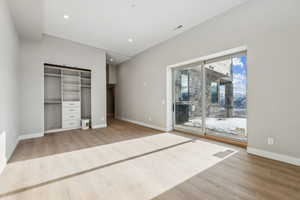 Unfurnished bedroom featuring access to exterior, visible vents, and wood finished floors