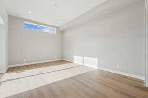 Spare room with baseboards and wood finished floors