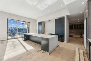 Kitchen featuring recessed lighting, modern cabinets, baseboards, and a spacious island